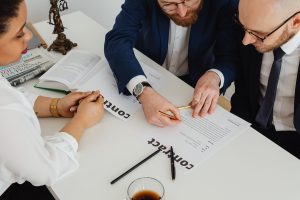 Business professionals reviewing contract documents before approval.
